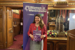 Theo Clarke MP holding her copy of Women in Westminster: The 100